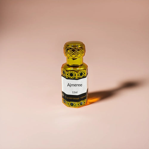 Ajmeree attar in golden bottle and mix peach background